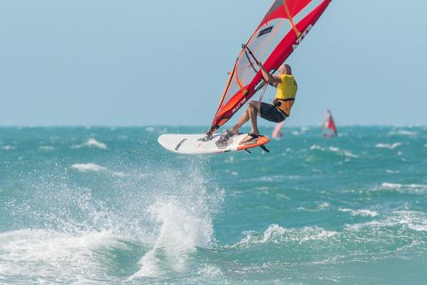 Pushing the nose downwind with the front foot and leg boosts our jumps and loops.    Photo by Nicolas Jones.