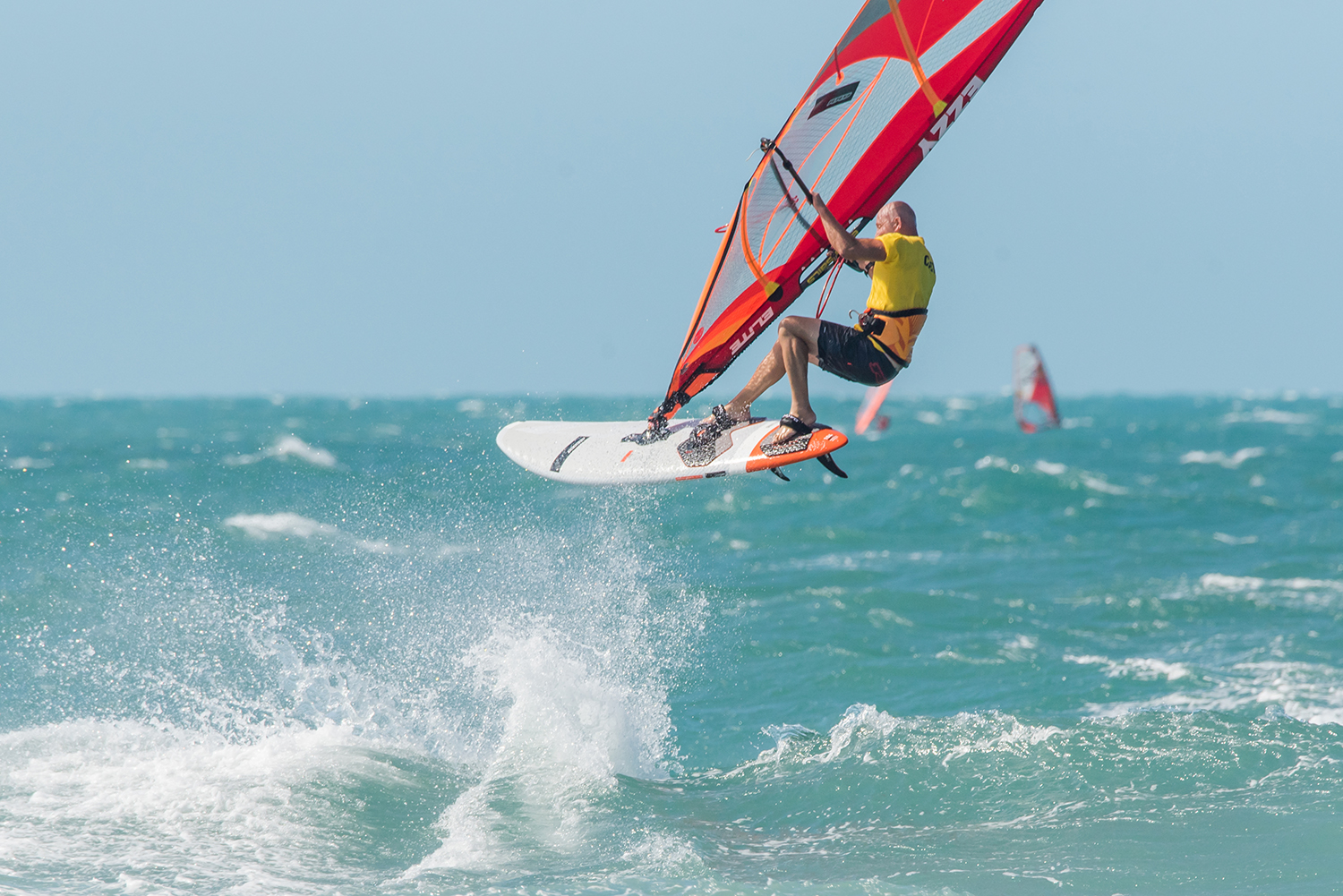 Pushing the nose downwind with the front foot and leg boosts our jumps and loops.    Photo by Nicolas Jones.