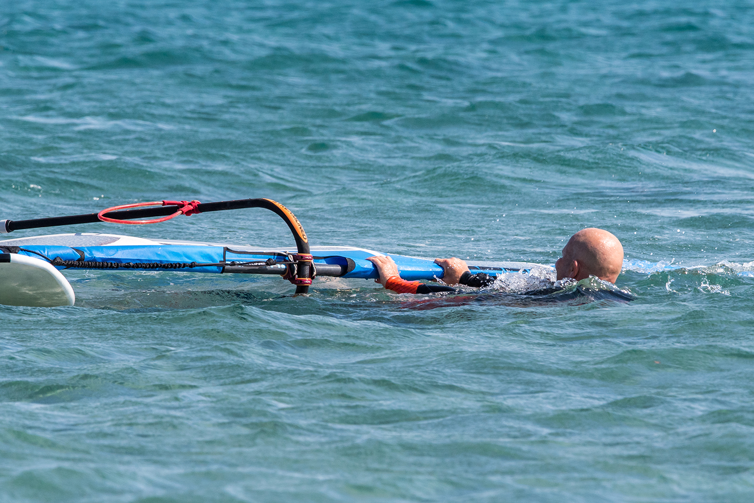 Swimming backwards towards the wind helps both you and the wind clear the sail for the 'airplane' method