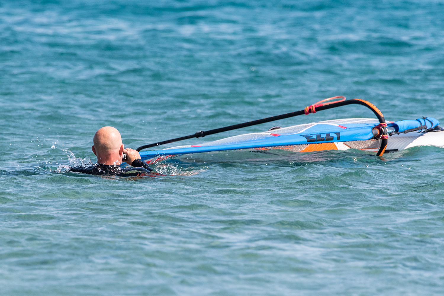 When the rig falls into the wind it’s best to clear the rig from the mast tip. Check your wind direction and swim to the mast tip, lift it up with your front hand and bring it into the wind and give it a shake. It helps to be swimming backwards slightly.