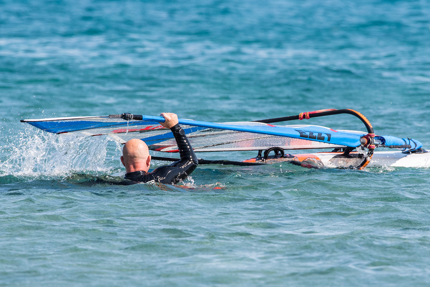 As you lift the rig continue to swim backwards and ensure you keep the rig flying, i.e. mast arm extended. You can slide your hand down the mast from the very top.