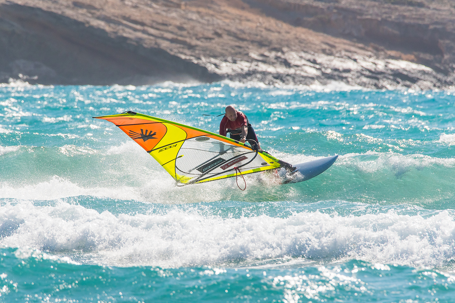 Push out on the back hand to help you ‘fall over’ onto the rig and transfer more weight to the toeside. This ‘backwinding’ of the rig will support you, believe me. The changing of the rails will expose more board to the wave, so the energy of it can redirect you.