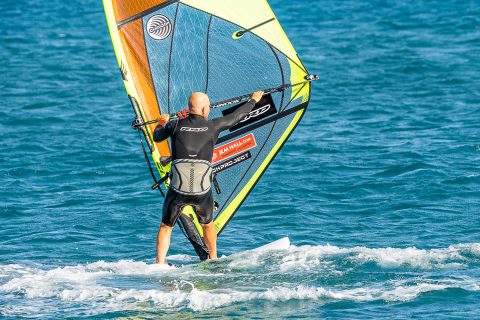 Big slide of the front (mast hand) all the way to the front of the boom as you keep looking forward. Then you are ready to release the back hand and actively guide the rig back for a slick rig rotation.