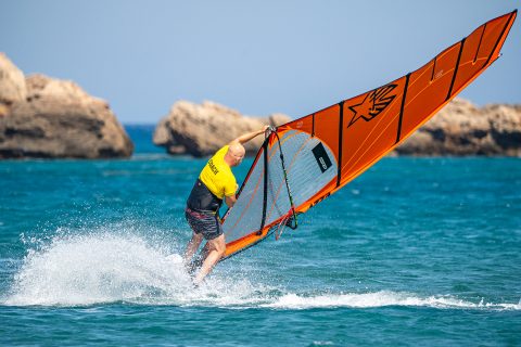 Keep your ankles and knees driving forward. Having the back of the boom in front of you really helps this. Then it is time to actually duck - to keep you low, look and pull the rig hard across you. Send rig to the outside of the turn, as you move to the inside.