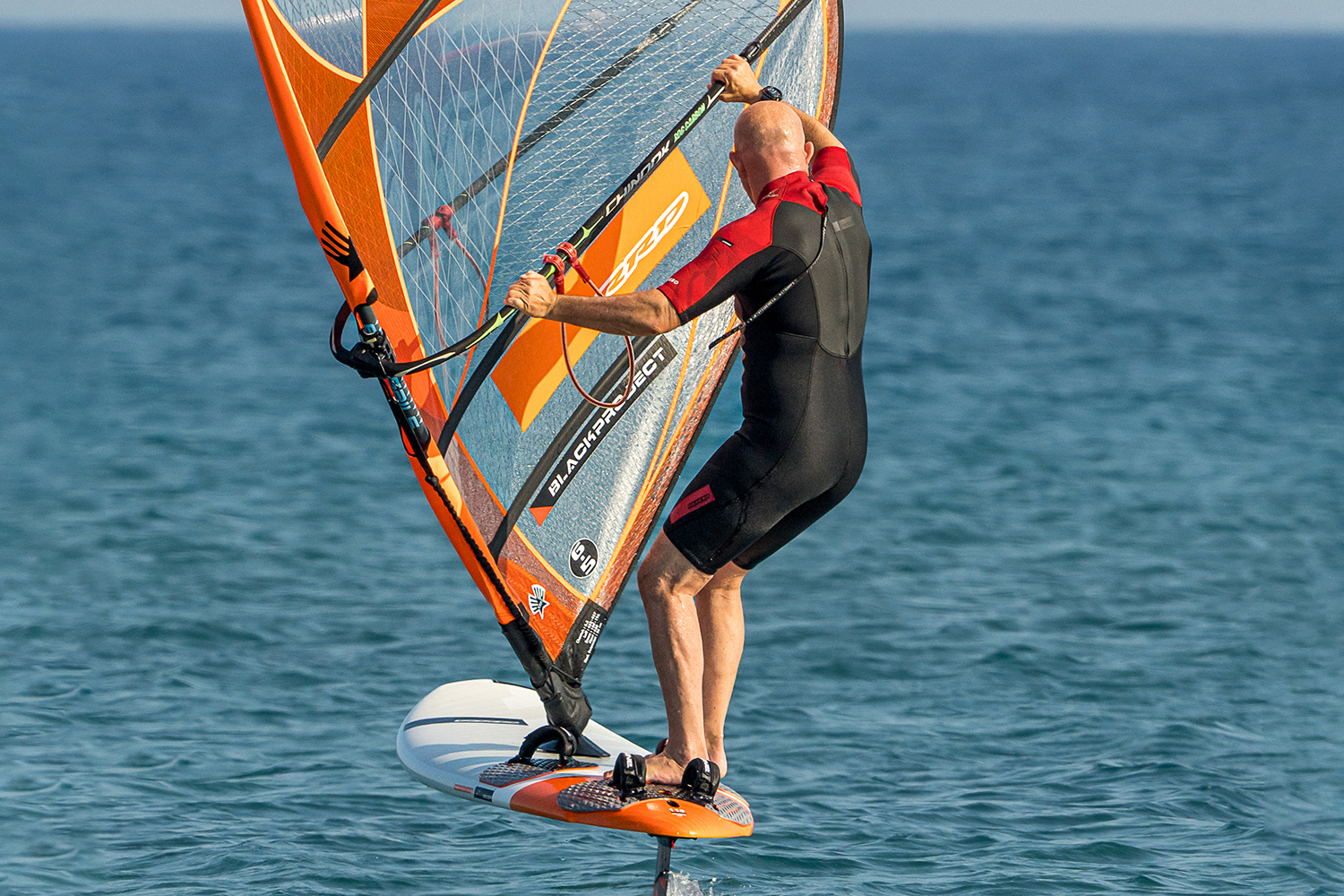 Switch the new front foot into the strap and get stable clew first and aim to maintain staying up on foil by sheeting out on the mast hand. Focus on keeping the rig away to give you some power so it can keep you up on the foil. You will get more accustomed to the required pressure on the back foot; either more to keep the nose up, or less to keep it down. If you touch down, then just get stable clew first, have your weight back and then rotate the rig and pump to get back on foil again.