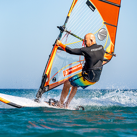Unhook, by bending elbows and staying outboard. Get feet out of the footstraps, back foot first. Pulling down on your arms really makes this smoother. Place your back foot next to front straps.