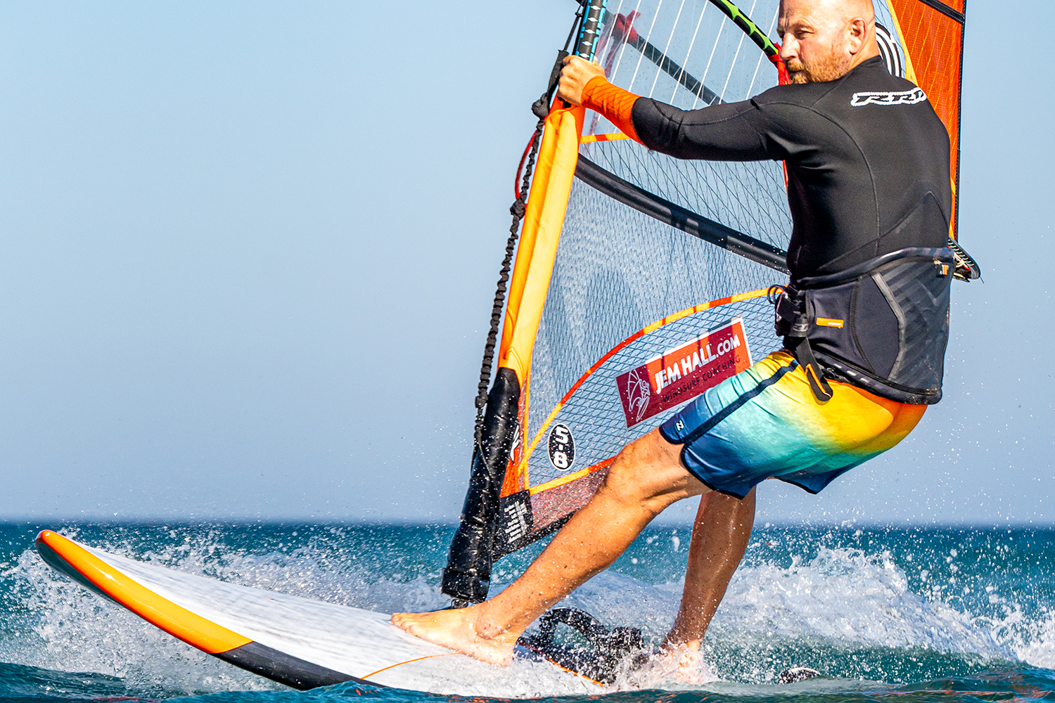 Now take front foot from the strap to in front of mastfoot, pulling down on the mast maintains your speed. Carve towards the wind (looking forward), on your heels, raking the rig back and moving your hips forwards and out (more than I am here).
