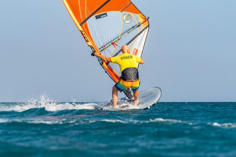 Reach under and collect the new side of the boom with an overhand grip as you keep low and carve off the heels.