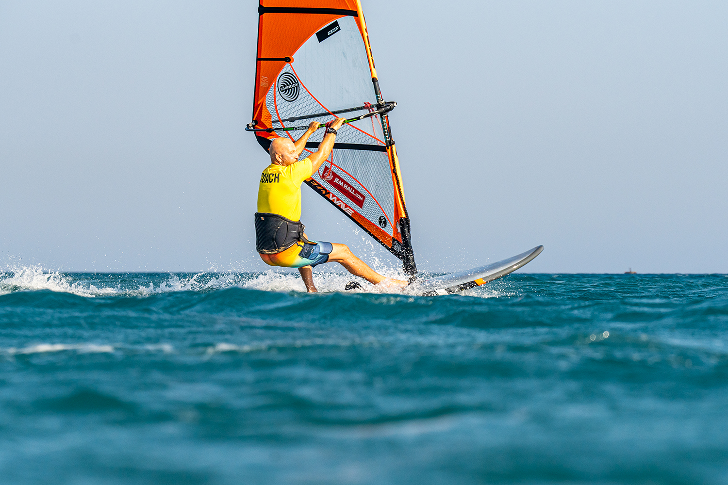 Drive the rig forward and get your hands next to the lines as you pull down on the boom and push the board forward through a straight front leg and bent back leg.